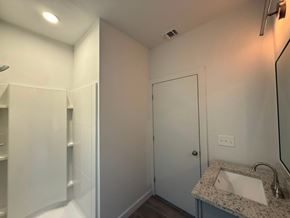 San Antonio apartment for rent - A white bathroom with a sink, mirror, and shower.