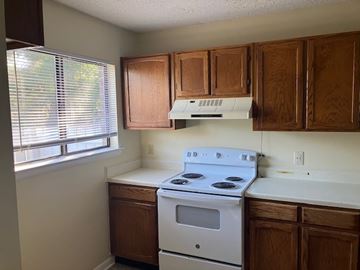 Beaufort - Coming Available 7/31/26 apartment for rent - A white stove in a kitchen with wooden cabinets.