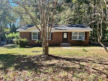 Charlotte house for rent - a small brick house with a tree in the yard