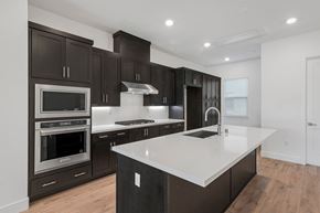 Sunnyvale house for rent - a kitchen with dark cabinets and white counter tops and a large island