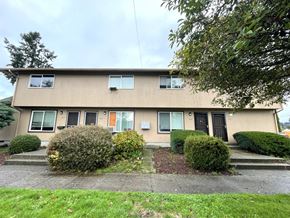 Kelso apartment for rent - A beige house with a black door and windows.