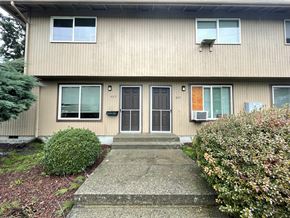 Kelso apartment for rent - A house with a grey front door and a small bush in front.
