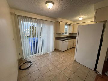 Kelso apartment for rent - A kitchen with a refrigerator, sink, and cabinets.