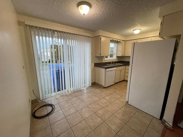 Kelso apartment for rent - A kitchen with a refrigerator, sink, and cabinets.