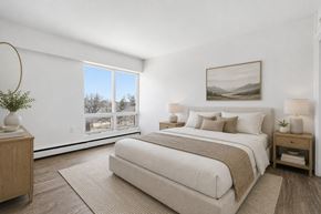 Regina apartment for rent - A bedroom with a large bed and a painting on the wall.