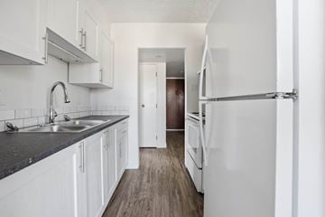 Regina apartment for rent - A kitchen with white cabinets and a black counter top.