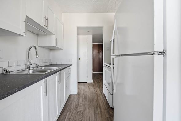 Regina apartment for rent - A kitchen with white cabinets and a black counter top.