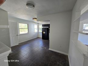 Hazelwood house for rent - an empty living room with white walls and tile floors