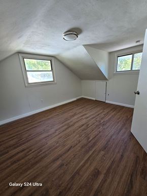 Hazelwood house for rent - an empty bedroom with hardwood floors and two windows