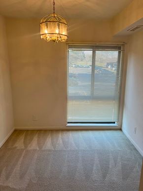 Columbia house for rent - A room with a carpeted floor, a chandelier, and a window with blinds.
