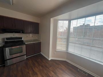 Laurel house for rent - A kitchen with dark wood cabinets and a stainless steel oven.