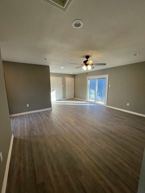 Abilene house for rent - A room with wooden floors and a ceiling fan.