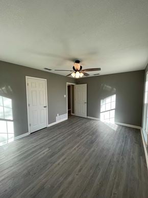 Abilene house for rent - A room with a ceiling fan and wood flooring.