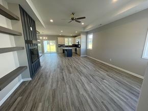 Wilson house for rent - a living room with a wood floor and a ceiling fan