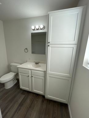 Lima apartment for rent - A white bathroom with a toilet, sink, and medicine cabinet.