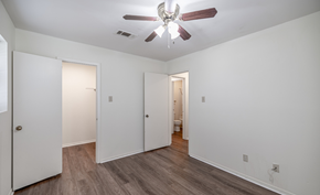 Russellville apartment for rent - A room with a ceiling fan and wooden floors.