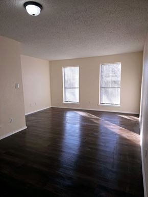Atoka apartment for rent - A room with wooden floors and two windows.