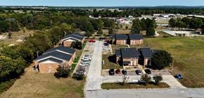 Atoka apartment for rent - A large building complex with a parking lot in front.