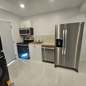 Fort Lauderdale apartment for rent - A modern kitchen with stainless steel appliances and white cabinets.