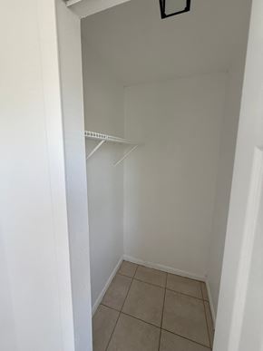 Fort Myers apartment for rent - A white closet with a shelf and tiled floor.