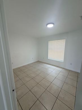 Fort Myers apartment for rent - A room with a tiled floor and a window with blinds.