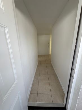 Fort Myers apartment for rent - A hallway with white walls and tiled flooring.