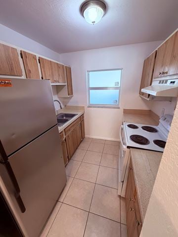 Fort Myers apartment for rent - A kitchen with a stove top oven and a refrigerator.