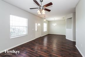 Lakeland house for rent - an empty living room with wood floors and a ceiling fan