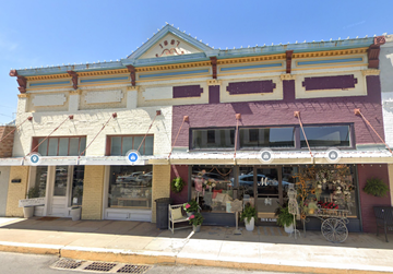 Brenham apartment for rent - A two-story building with a storefront on the bottom and a balcony on the top.