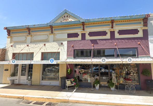 Brenham apartment for rent - A two-story building with a storefront on the bottom and a balcony on the top.