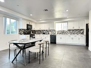 Los Angeles apartment for rent - a kitchen with white cabinets and a table with chairs