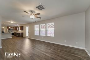 Charlotte house for rent - an empty living room with a ceiling fan and a kitchen