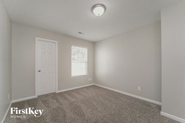 Charlotte house for rent - a bedroom with carpet and a white door and a window
