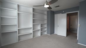 Mesquite house for rent - an empty room with white shelves and a ceiling fan