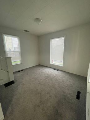 Lima apartment for rent - A room with a carpeted floor, two windows, and a smoke detector on the ceiling.