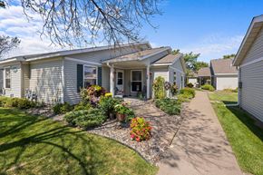 Oakdale apartment for rent - A house with a grey siding and a small front yard with a flower bed.