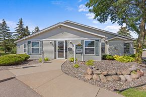 Oakdale apartment for rent - A house with a grey siding and a stone pathway leading to the front door.