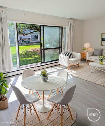 Surrey apartment for rent - A living room with a white table and chairs, a lamp, and a plant.