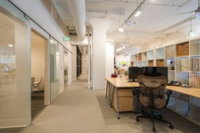 Cleveland apartment for rent - A modern office with a glass wall and a desk with a computer and chair.