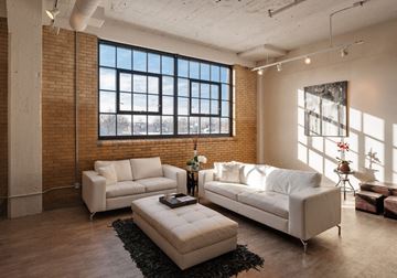 Cleveland apartment for rent - A living room with a white couch and a black rug.