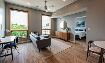 Cleveland apartment for rent - A living room with a grey couch and a white table.