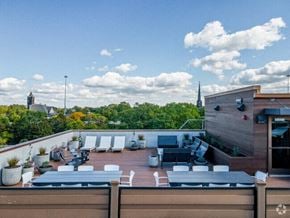 Cleveland apartment for rent - A rooftop patio with a table and chairs overlooking a church.