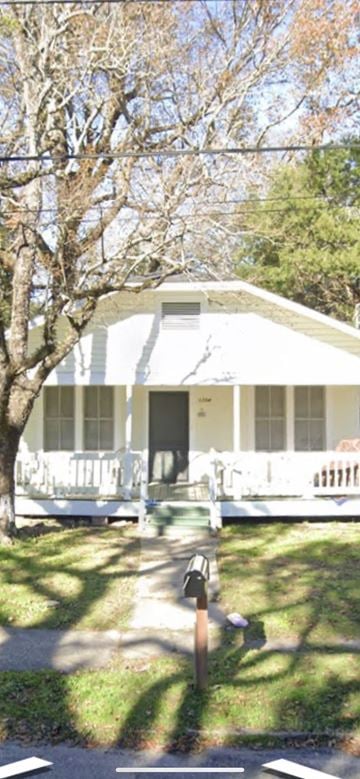 Mobile house for rent - A white house with a black door and a mailbox on the sidewalk.