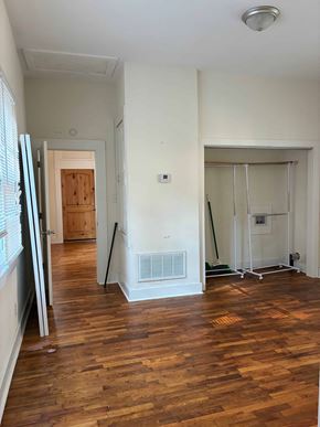 Mobile house for rent - A room with wooden floors and white walls.