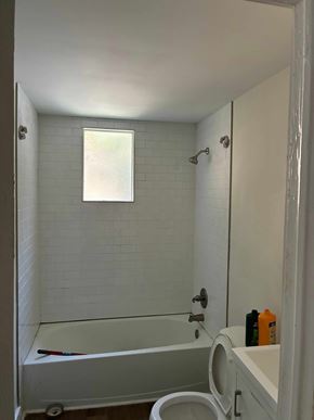 Mobile house for rent - A white bathroom with a tub, toilet, and sink.