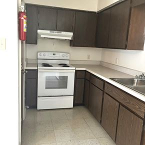 Gonzales apartment for rent - an empty kitchen with white appliances and wooden cabinets