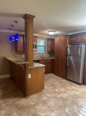 Baton Rouge apartment for rent - A kitchen with a refrigerator, cabinets, and a marble countertop.