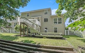 Kentwood house for rent - the back of an apartment building with a wooden deck and stairs