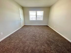 Louisville apartment for rent - A room with a brown carpet and a window.