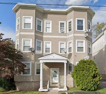 Chicopee apartment for rent - A beige two-story house with a white front door and steps.